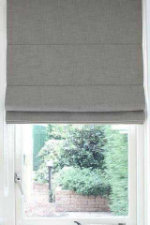 Licht beige vouwgordijn op raam gemonteerd